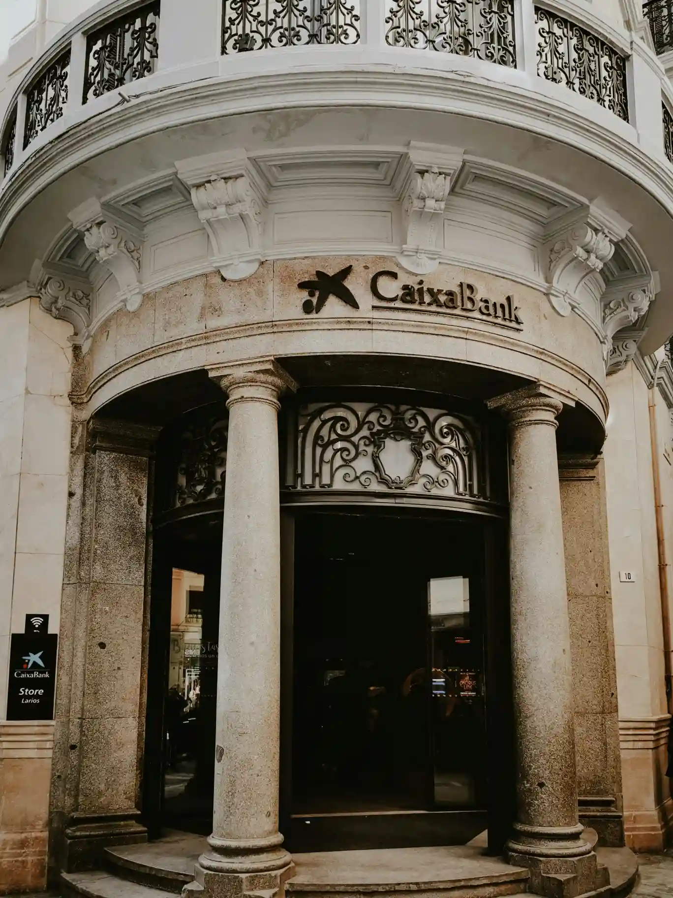 un moderno edificio bancario fusionado con hologramas dorados de bitcoin simbolizando a caixabank y la licencia mica de criptomonedas